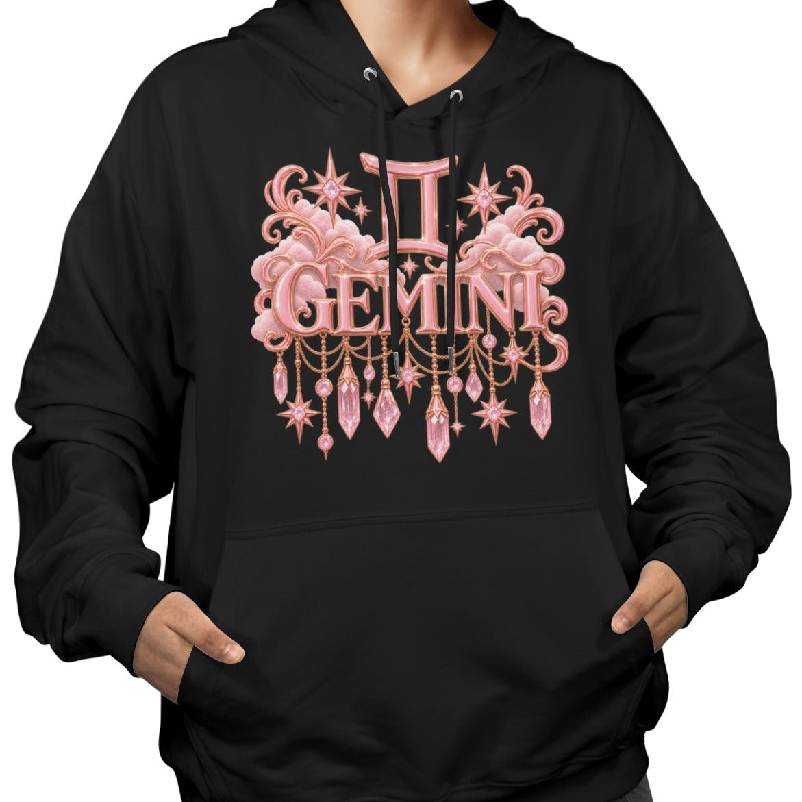 A woman wearing a black pullover hoodie with a pink and gold Gemini zodiac graphic on the front, set against a plain white background.