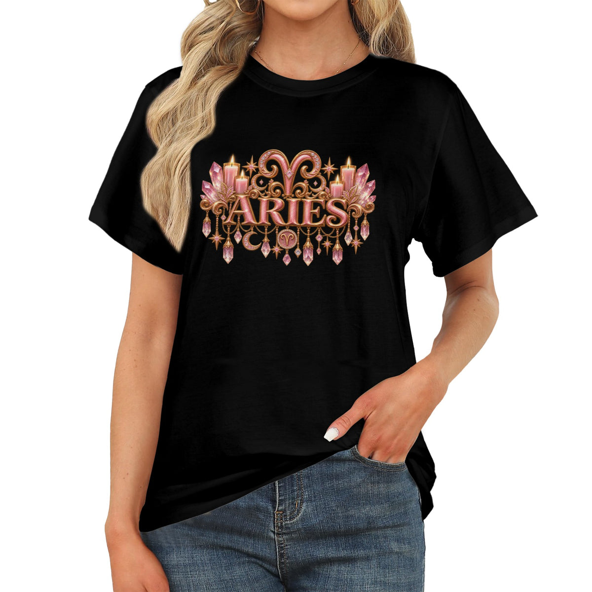 A woman wearing a black short-sleeve graphic T-shirt with a decorative pink and gold 'ARIES' design on the chest, paired with blue jeans against a plain white background.